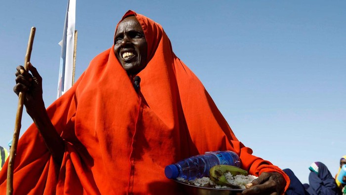 Potret Pengungsi Somalia Antre Menu Berbuka Puasa An internally displaced Somali woman walks after receiving iftar food rations for Ramadan in the outskirt of Mogadishu, Somalia, March 20, 2024 REUTERS/Feisal Omar