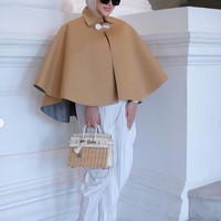 Di unggahan terbaru akun Instagram pribadinya Syahrini tampak memadukan outer cape berwarna coklat dengan celana putih plisket. Penampilannya itu kemudian dilengkapi dengan hijab berwarna coklat, sepasang heels, dan kaca mata hitam. Foto: Instagram/@princessyahrini