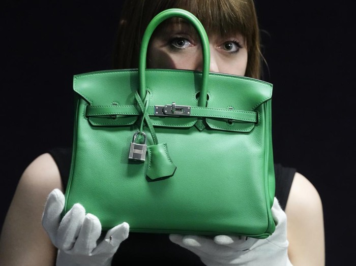 A Bonhams employee displays a Hermes: a Bambou Swift Leather Birkin 25 bag, at the auction rooms in London, Monday, Feb. 26, 2024. The bag estimated at 12,000-18,000 UK Pounds (15,000-22,800 US Dollars) will be for auction in the live sale on Feb. 28, it will feature luxurious items of handbags and ready-to-wear designs from coveted names including Chanel, Hermes, Karl Lagerfeld for Chanel, Christian Dior, Louis Vuitton, and Gucci. (AP Photo/Kirsty Wigglesworth)