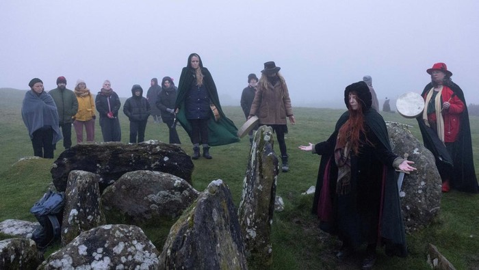 Warga Irlandia Sambut Terbit Matahari Saat Fenomena Equinox Revellers celebrate the arrival of Spring Equinox on top of Sliabh na Caillaigh at dawn to watch the sunrise during bad weather over the ancient Loughcrew megalithic cairns, in Oldcastle, Ireland, March 20, 2024. REUTERS/Clodagh Kilcoyne TPX IMAGES OF THE DAY