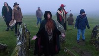 Mereka tetap berkumpul di bukit untuk merasakan hangatnya matahari meski di tengah cuaca berkabut.  