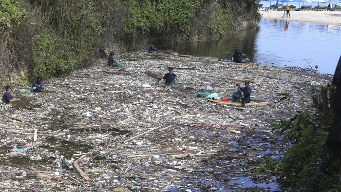 Aksi Bule Bersih-bersih Sampah di Sungai Pecatu Bali Volunteers pick up trash on a river which is covered with trash at Pecatu, Bali, Indonesia on Friday, March 22, 2024. During monsoon season some rivers are being strewn by plastic rubbish and debris. Local authorities and communities are urging for serious action on clean-up. (AP Photo/Firdia Lisnawati)