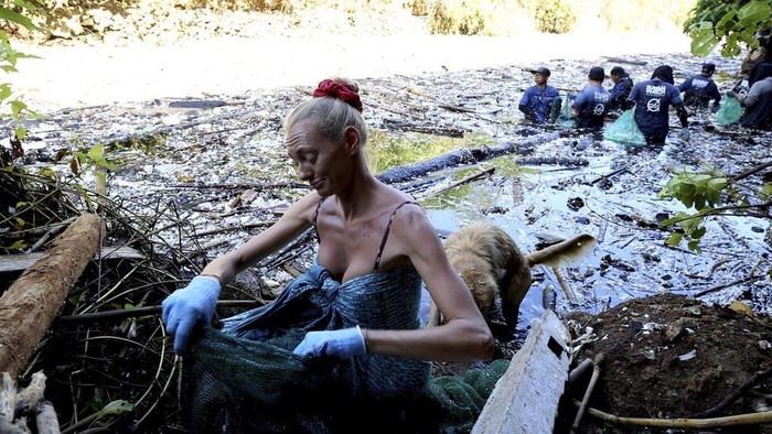 Volunteers pick up trash on a river which is covered with trash at Pecatu, Bali, Indonesia on Friday, March 22, 2024. During monsoon season some rivers are being strewn by plastic rubbish and debris. Local authorities and communities are urging for serious action on clean-up. (AP Photo/Firdia Lisnawati)