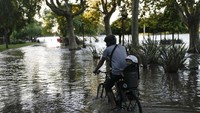 Warga lainnya menembus banjir dengan sepeda. 
