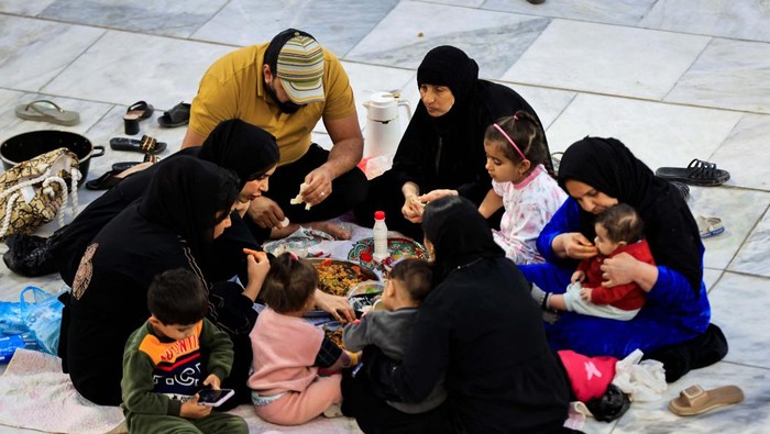 Iraqi Muslims eat Iftar, the meal to end their fast at sunset, during the holy fasting month of Ramadan at the shrine of cleric Sheikh Abdul Qadir al-Gailani in Baghdad, Iraq, March 21, 2024. REUTERS/Thaier Al-Sudani