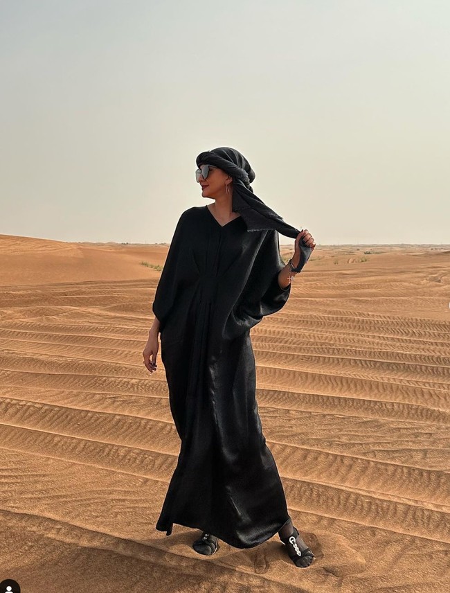 Berpose di gurun pasir, Donna juga terlihat mengenakan kaftan berwarna hitam. Penampilannya itu dilengkapi dengan sorban ala wanita Dubai dan kaca mata hitam. Foto: Instagram/@dagnesia