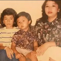 Ini foto Ussy Sulistiawati saat masih kecil bersama keluarganya. Ia duduk di antara kedua saudaranya. Istri Andhika Pratama ini terlihat manis dengan gaya rambut khas 80-an. Foto: Instagram