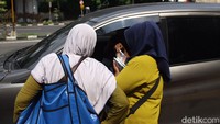 Para jasa penukaran uang menghampiri para pengendara untuk menawarkan uang baru.