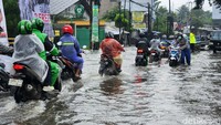 Pengendara menerobos banjir di Jl HOS Cokroaminoto, tak jauh dari halte bus TransJakarta Puri Beta, Kota Tangerang, Jumat (22/3/2024).