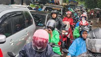 Pengendara roda dua harus bersabar di bawah gerimis hujan. 
