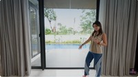Di samping ruang TV terdapat pintu kaca yang mengarah ke kolam renang.