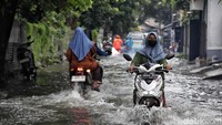 Para pemotor terlihat menerobos banjir.    