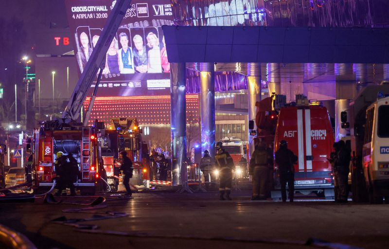 Vehicles of Russian emergency services are parked near the burning Crocus City Hall concert venue following a reported shooting incident, outside Moscow, Russia, March 22, 2024. REUTERS/Maxim Shemetov     TPX IMAGES OF THE DAY