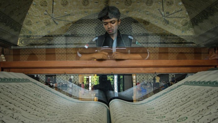 Melihat Al-Qurβan Raksasa di Masjid Raya Makassar Jamaah melihat Al Quran berukuran raksasa di Masjid Raya Makassar, Sulawesi Selatan, Sabtu (23/3/2024). Al Quran yang ditulis oleh pendiri Pondok Pesantren Al-Asy'ariah Wonosobo, Jawa Timur KH Ahmad Faqih Al-Muntaha tersebut berukuran 1 x 1,5 meter dan menjadi daya tarik wisata religi di daerah itu. ANTARA FOTO/Arnas Padda/rwa.