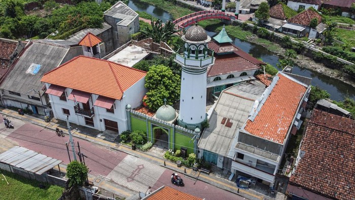 Mengenal Cagar Budaya Masjid Menara Layur di Semarang Foto udara seorang pengendara motor melintas di depan Masjid Menara Layur, Semarang, Jawa Tengah, Sabtu (23/3/2024). Masjid yang memiliki nama lain yakni Masjid Menara Kampung Melayu dan ditetapkan sebagai bangunan cagar budaya pada tahun 1992 oleh Pemkot Semarang tersebut dibangun pada tahun 1802 Masehi oleh beberapa saudagar asal negara Yaman yang kala itu bermukim di wilayah itu dan hingga kini masih bertahan sebagai salah satu pusat syiar Islam tertua di Kota Semarang. ANTARA FOTO/Makna Zaezar/rwa.