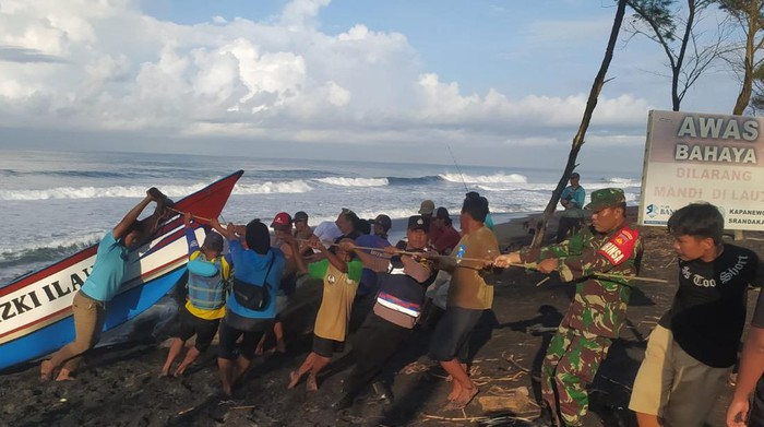 Tim SAR Satlinmas dibantu warga dan personil TNI dan Polri mengevakuasi perahu terbalik di Pantai Baru, Srandakan, Bantul, Sabtu (23/3/2024).