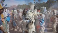 “Perang tepung” ini mempertemukan orang-orang yang bersuka ria dengan berton-ton tepung masak yang diwarnai dengan pewarna makanan.  