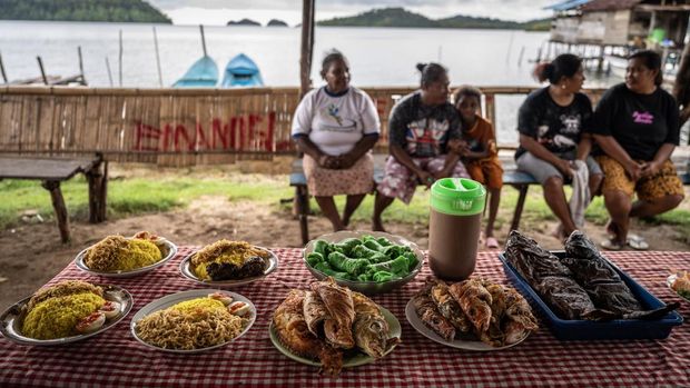 Empat mama Papua duduk di dekat hidangan yang dijual saat Bazar Makanan di Kampung Kapatcol, Distrik Misool Barat, Kabupaten Raja Ampat, Papua Barat Daya, Minggu (24/3/2024). Kegiatan yang diselenggarakan warga dengan menjual berbagai macam makanan khas kampung itu hasilnya untuk memenuhi kebutuhan tempat beribadah atau adanya kebutuhan mendesak di Kampung Kapatcol. ANTARA FOTO/Bayu Pratama S/Spt.