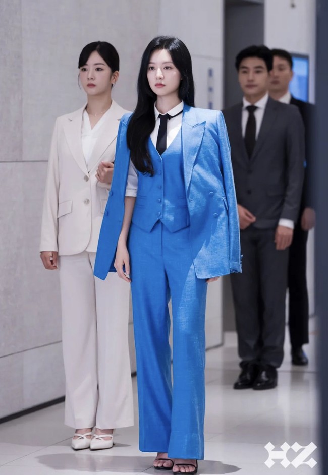 Lihat pula gaya Kim Ji Won dengan setelan kemeja putih, vest dan celana biru muda. Tambahan blazer di pundak serta dasi hitam panjang membuat penampilannya tampak mendominasi. Foto: Instagram @queenoftears_tvn