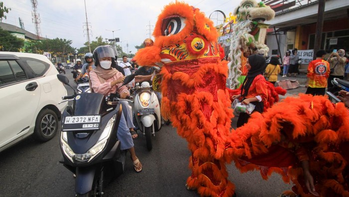 Kelompok kesenian barongsai membagikan takjil kepada pengguna jalan saat kegiatan bagi-bagi takjil umat Buddha dari Wihara Dharma Bhakti Sidoarjo di jalan Ponti, Sidoarjo, Jawa Timur, Minggu (24/3/2024). Kegiatan berbagi tersebut merupakan bentuk kepedulian antarumat beragama terutama di bulan Ramadhan. ANTARA FOTO/Umarul Faruq/aww.