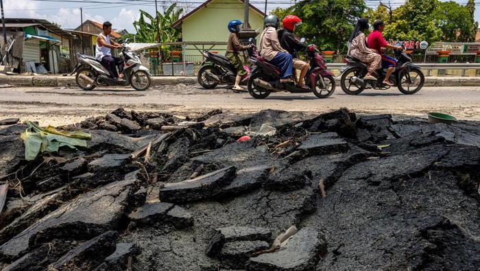 Penampakan Jalur Pantura Demak-Kudus Rusak Pascabanjir Kendaraan bermotor melaju perlahan saat melintasi jalan yang rusak terdampak banjir di jalur utama pantura Demak-Kudus Kilometer 44 di Kecamatan Karanganyar, Kabupaten Demak, Jawa Tengah, Minggu (24/3/2024). Bupati Demak Esti'anah telah memerintahkan Dinas Pekerjaan Umum dan Penataan Ruang Kabupaten Demak mendata seluruh ruas jalan rusak terdampak banjir yang kemudian diprioritaskan untuk perbaikan pada kewenangan wilayah jalan pemerintah pusat, provinsi, dan daerah sesuai dengan arahan Presiden Joko Widodo saat memantau penanganan banjir Demak pada Jumat (22/3). ANTARA FOTO/Aji Styawan/Spt.