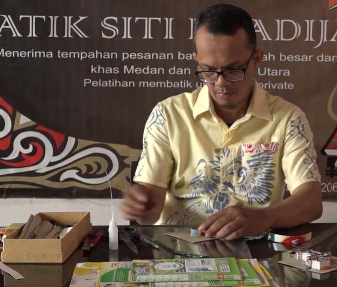 Reza tengah mengolak kotak susu untuk dibuat cap kain batik (Foto: Dok. Reza Ansari)