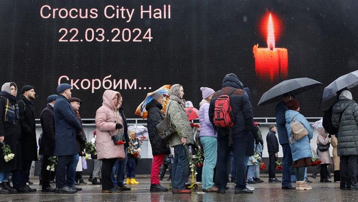 People gather at a makeshift memorial to the victims of a shooting attack set up outside the Crocus City Hall concert venue in the Moscow Region, Russia, March 24, 2024. REUTERS/Maxim Shemetov