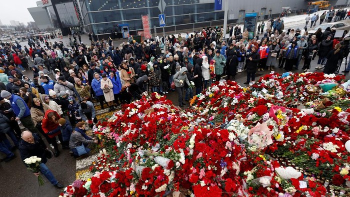 People gather at a makeshift memorial to the victims of a shooting attack set up outside the Crocus City Hall concert venue in the Moscow Region, Russia, March 24, 2024. REUTERS/Maxim Shemetov