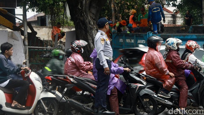 Banjir Surut, Lalin Pertigaan Hek Kramat Jati Masih Macet Petugas Dishub mengatur lalu lintas di pertigaan Hek Kramat Jati, Jakarta Timur, Senin (25/3/2024).