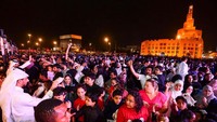 Seorang pria membagikan sekantong permen kepada anak-anak pada perayaan Garangao di Pasar Tradisional Souq Waqif di Doha, Qatar, pada 24 Maret 2024.