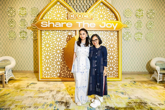 Ia kemudian melengkapi gaya dengan alas kaki karet khas keluaran Crocs yang sempat populer kembali berkat kemunculan tren ugly shoes. Sandal berbentuk buaya itu juga dipercantik dengan berbagai jibbitz (ornamen untuk alas kaki keluaran merek asal Amerika Serikat itu) berkilauan dan sentuhan pita. (Foto: Dok. Crocs Indonesia)