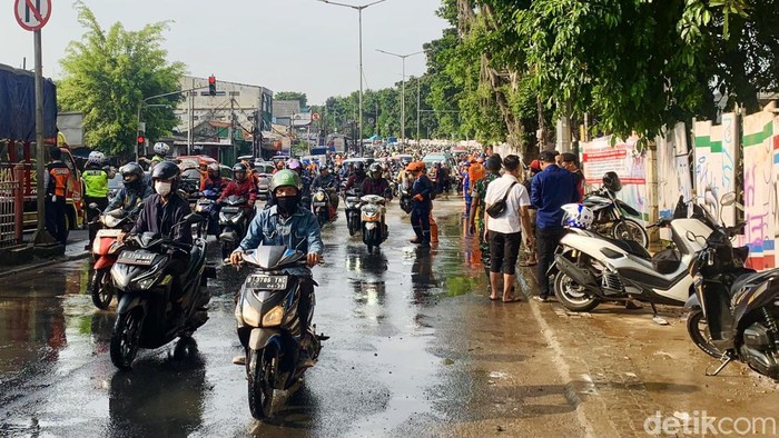 Sejumlah petugas mengatur lalu lintas di pertigaan Jl Raya Bogor di Kawasan Hek Kramat Jati, Jakarta Timur, Senin (25/3/2024). Kawasan Hek Kramat Jati, Jakarta Timur kini kebanjiran lagi. Pihak Dinas Sumber Daya Air (SDA) DKI Jakarta menepis informasi bahwa banjir ini dikarenakan proyek tanggul yang mereka kerjakan jebol.