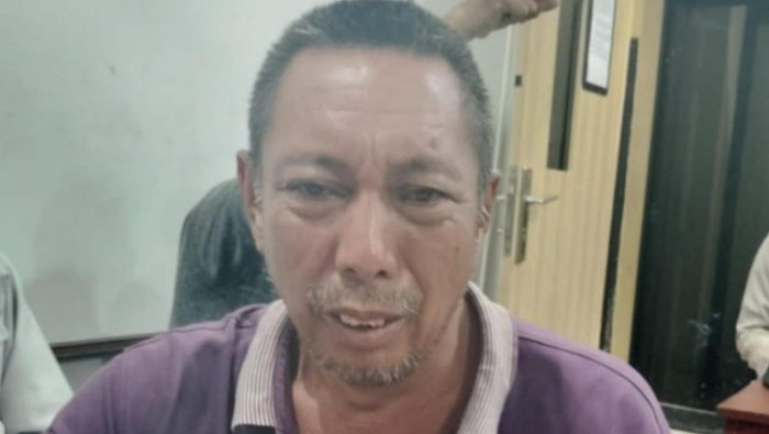 Imron saat diamankan di kantor polisi.