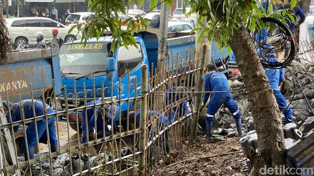 Kawasan Hek Kramat Jati, Jaktim, sempat banjir akibat air dari Kali Baru meluap. Petugas menangani kali luber tersebut dengan memasang kisdam dan bronjong. (Devi P/detikcom)