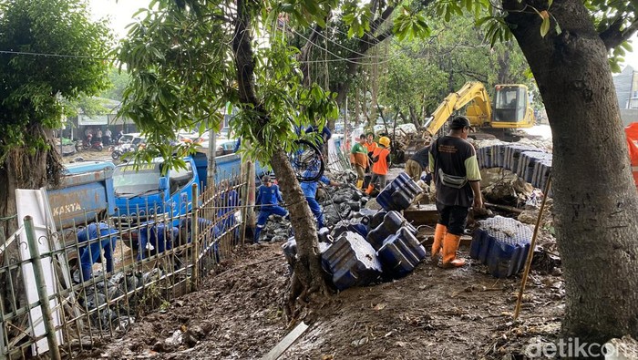 Kawasan Hek Kramat Jati, Jaktim, sempat banjir akibat air dari Kali Baru meluap. Petugas menangani kali luber tersebut dengan memasang kisdam dan bronjong. (Devi P/detikcom)