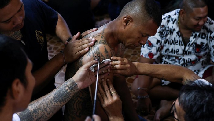 A devotee in trance mimics a beast during a religious tattoo festival at Wat Bang Phra monastery, where devotees believe that their tattoos have mystical powers, in Nakhon Pathom province, Thailand, March 23, 2024. REUTERS/Chalinee Thirasupa