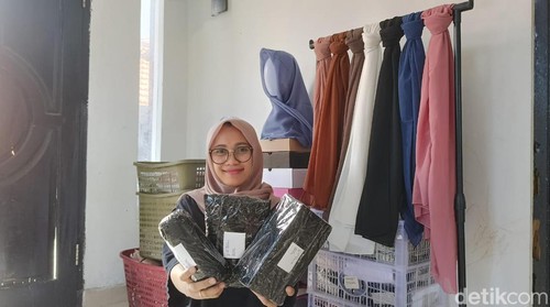 Noviana Windri Rahmawati menunjukkan sejumlah produk yang dijual Lugu Hijab. (Foto: Ni Made Lastri Karsiani Putri/detikBali)