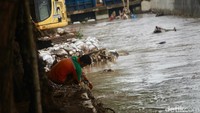 Petugas membersihkan sampah di lokasi meluapnya air kali Hek Kramat Jati, Jakarta Timur, Senin (25/3/2024).  