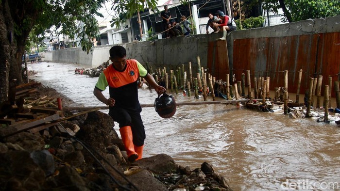 Petugas membersihkan sampah di lokasi meluapnya air kali Hek Kramat Jati, Jakarta Timur, Senin (25/3/2024).