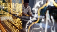 Seorang perajin menyelesaikan pembuatan kaligrafi Tulungagung, Jawa Timur, Minggu (24/3/2024).