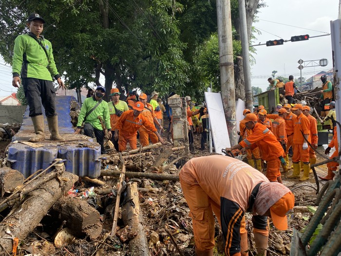 Petugas membersihkan sampah yang terbawa luapan air Kali Hek, Jakarta Timur (Devi/detikcom)