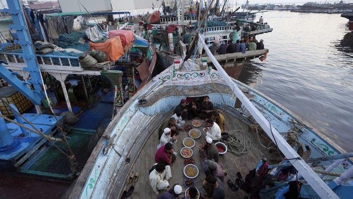 Pakistani fishermen attend prayer at a boat in the fish harbor on the Arabian Sea during the Muslim's holy fasting month of Ramadan, in Karachi, Pakistan, Sunday, March 24, 2024. (AP Photo/Fareed Khan)