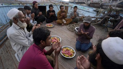 Potret Nelayan Pakistan Buka Puasa dan Salat di Atas Perahu
