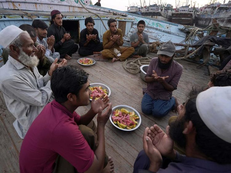 Potret Nelayan Pakistan Buka Puasa dan Salat di Atas Perahu
