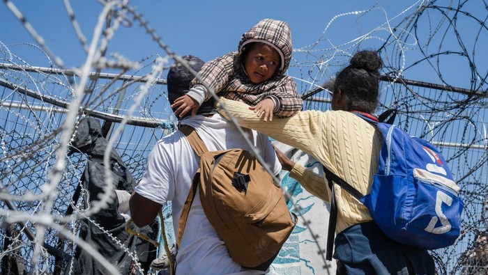 Potret Ratusan Imigran Terobos Kawat Berduri Serbu Perbatasan AS-Meksiko A group of migrants attempt to pull down the concertina wire deployed by Texas law enforcement officers, at the U.S.-Mexico border near El Paso, Texas, U.S., March 22, 2024. REUTERS/Justin Hamel