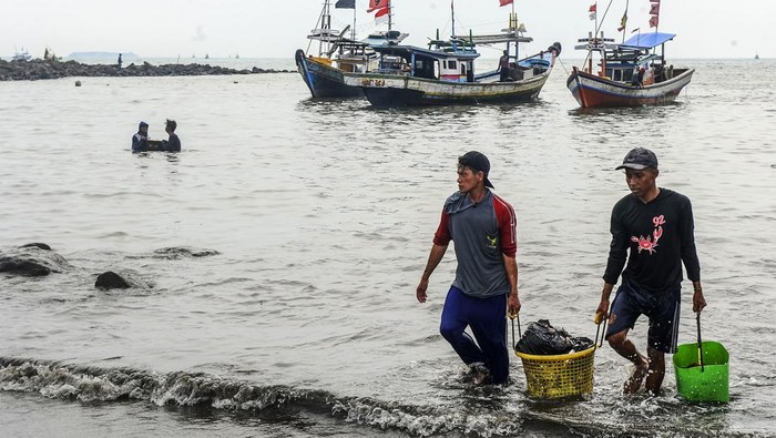Sedimentasi Bikin Kapal Nelayan Sulit Bersandar di Teluk Labuan Sejumlah nelayan mengangkut ikan hasil tangkapannya untuk dibawa ke pelelangan ikan di Teluk Labuan, Pandeglang, Banten, Minggu (24/3/2024). Nelayan di daerah tersebut mengeluhkan endapan pasir atau sedimentasi yang terjadi di Teluk Labuan berdampak pada sulitnya akses bongkar muat kapal sehingga mereka harus membawa sendiri ikan hasil tangkapan menuju pelalangan. ANTARA FOTO/Muhammad Bagus Khoirunas/rwa.
