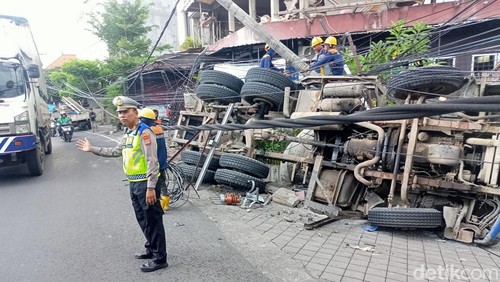 Truk molen dari arah Denpasar menuju Tabanan, terguling di Jalan Denpasar-Gilimanuk, Kelurahan Sempidi, Kecamatan Mengwi, Badung, Senin sore (25/3/2024). (Agus Eka Purna Negara/detikBali)
