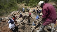 Mereka sedang membangun bendungan pasir, sebuah bangunan untuk menampung air dari sungai musiman. Penghalang tersebut, biasanya terbuat dari beton, menghalangi aliran air dan butiran pasir kasar mengendap di belakangnya, menciptakan akuifer buatan yang terisi selama musim hujan.