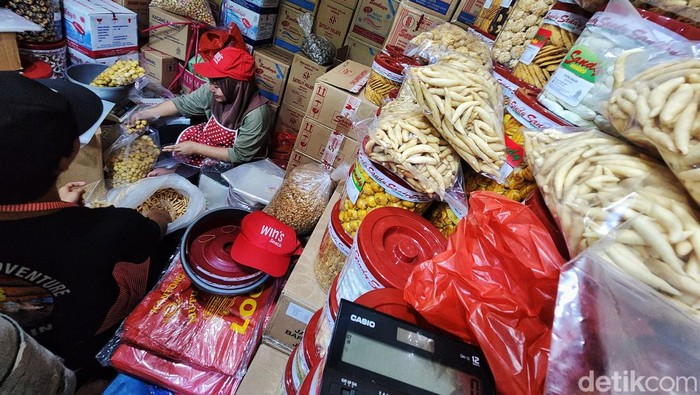 Meraup Cuan dari Kue Lebaran Para pedagang kue kering melayani pembeli di Pasar Jatinegara, Jakarta Timur, Selasa (26/3/2024). Aktivitas penjualan kue kering meningkat menjelang lebaran Idul Fitri 1445 H. Pasar Jatinegara menjadi langganan untuk belanja kue lebaran dari tahun ke tahun. Selain relatif lebih murah, bisa beli grosir dengan aneka macam kue selalu tersedia.