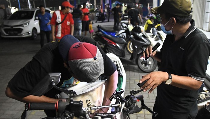 Seorang teknisi menumpahkan isi tangki bensin motor yang mogok  ke dalam dirigen usai mengisi di salah satu pom bensin di Jalan Ir Juanda, Bekasi, Jawa Barat, Selasa (26/3/2024) dini hari Menurut keterangan konsumen yang terdampak sebanyak puluhan kendaraan bermotor mogok usai isi bensin dan pihak dari pom bensin mengganti 100 persen biaya kerusakan kendaraan yang rusak. ANTARA FOTO/ Fakhri Hermansyah/foc.